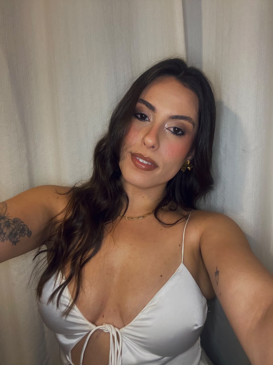 Bettina Poll em retrato com top de cetim claro e laço frontal